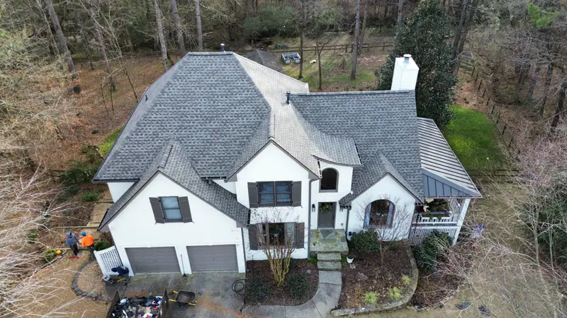 After: new architectural shingle roof on a large stucco home with multiple gables
